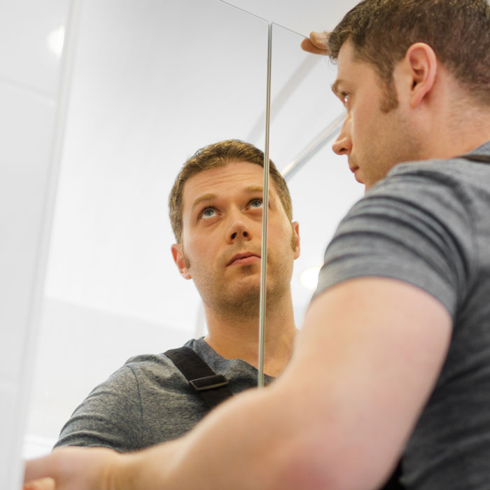 man installing large mirror