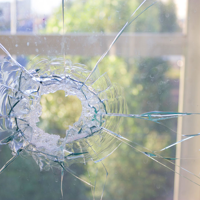 window with large hole and cracks